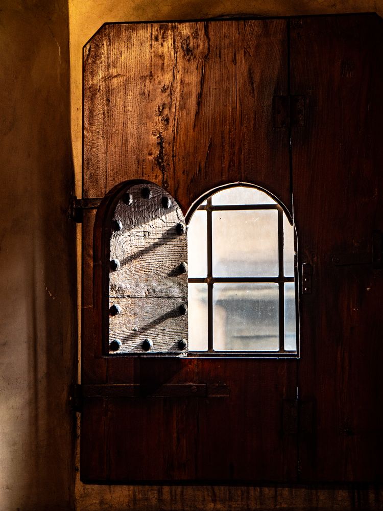 Old wooden shutter and window lit by warm afternoon light, Florence
