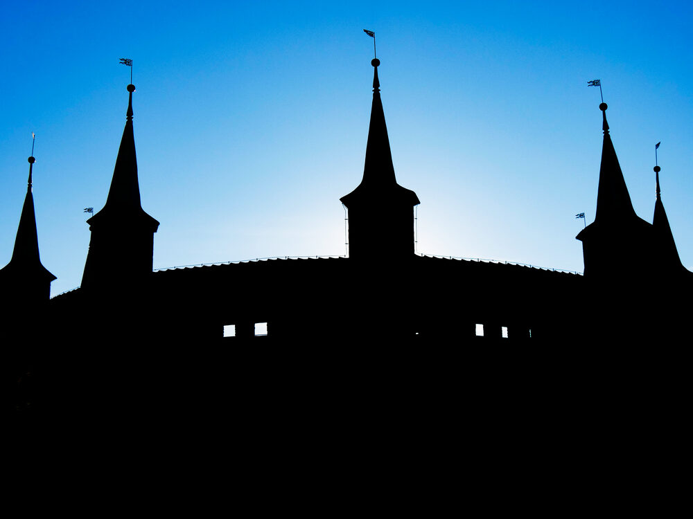 Silhouetted spires and flags of Krakow's old defences against a blue dusk sky, Poland