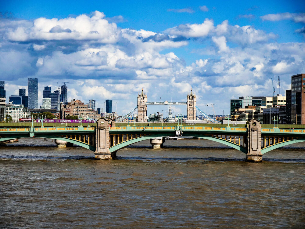 Southwark Bridge crossing the Thames with Tower Bridge and the city skyline behind, London