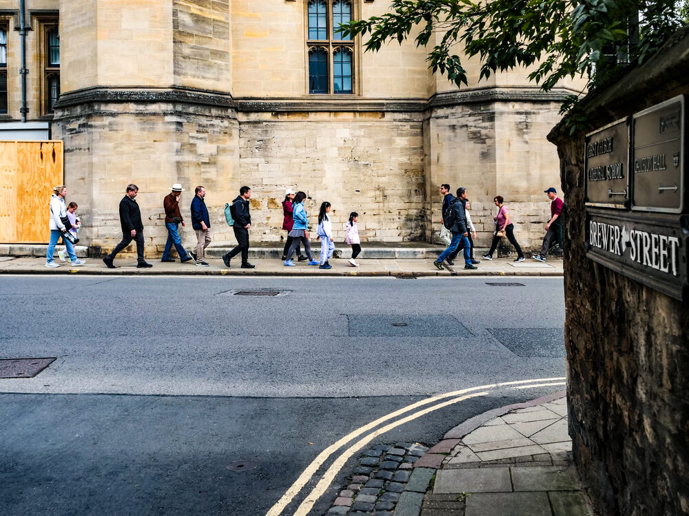 A line of people on a walking tour passing the Brewer Street corner, Oxford