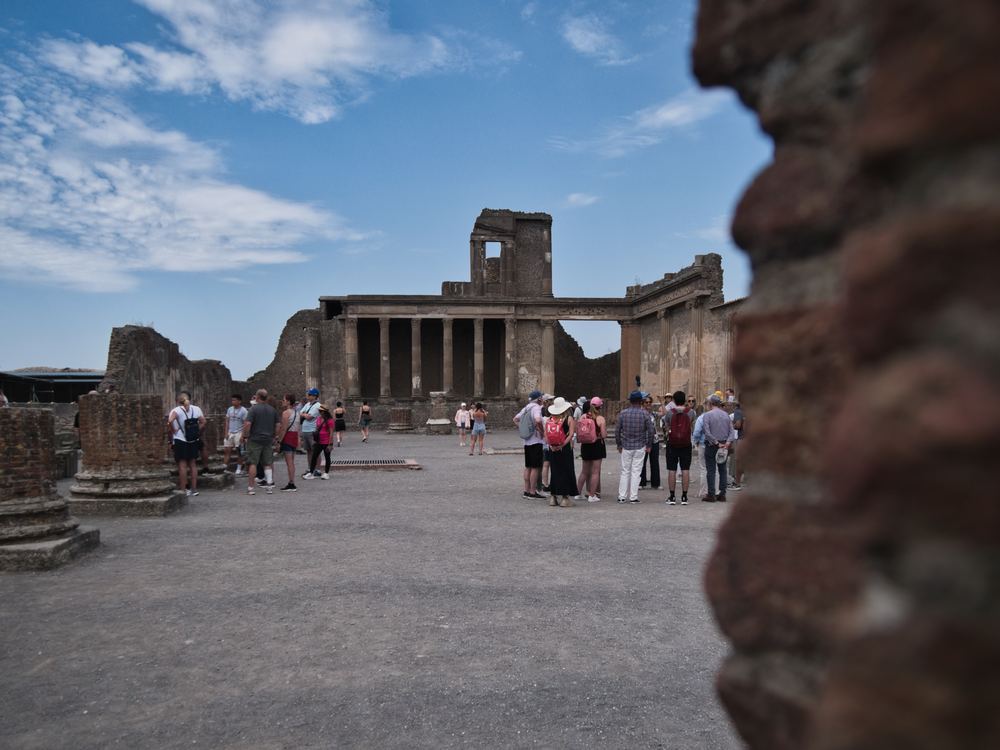 Ruins of the forum at Pompeii with visitors walking through