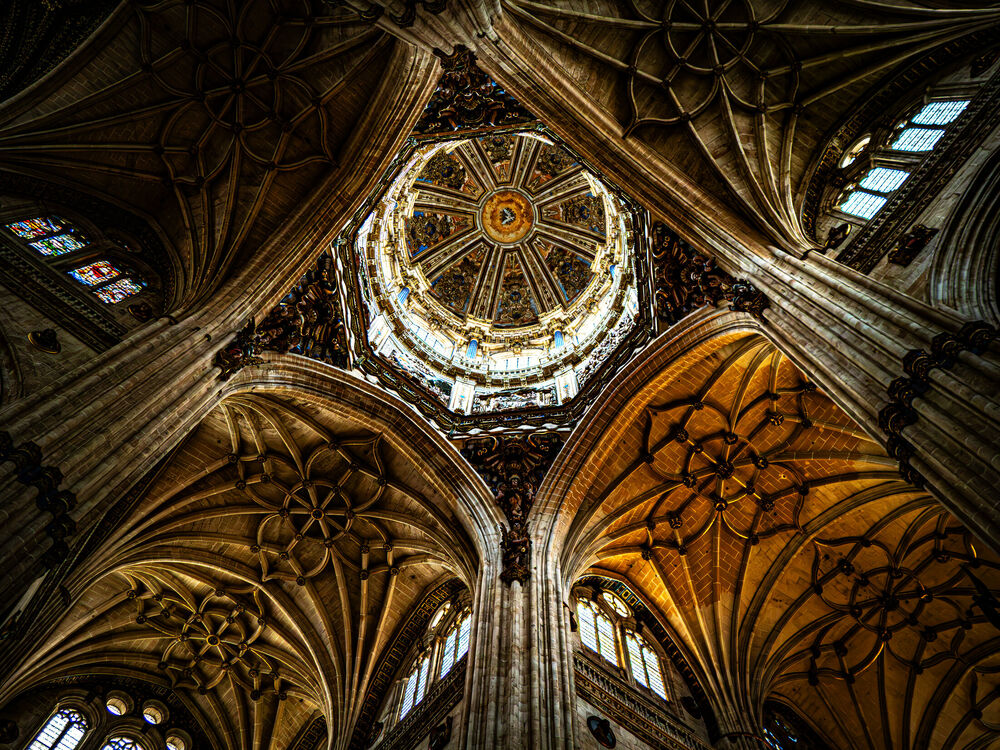 Looking straight up at the ornate crossing dome and ribbed vaults of Salamanca's New Cathedral